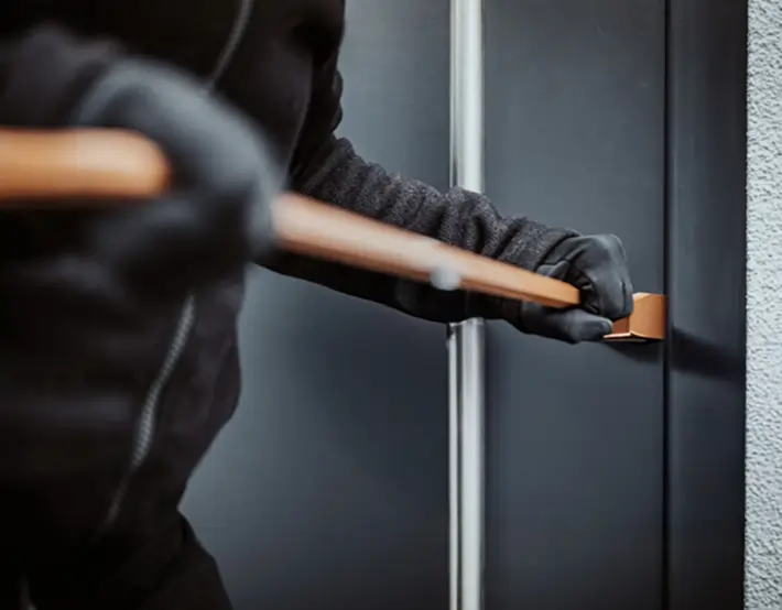 Попытка взлома двери ломом, символизирующая защиту от взлома